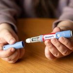 Hands holding an Ozempic injection pen