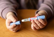 Hands holding an Ozempic injection pen