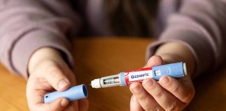 Hands holding an Ozempic injection pen