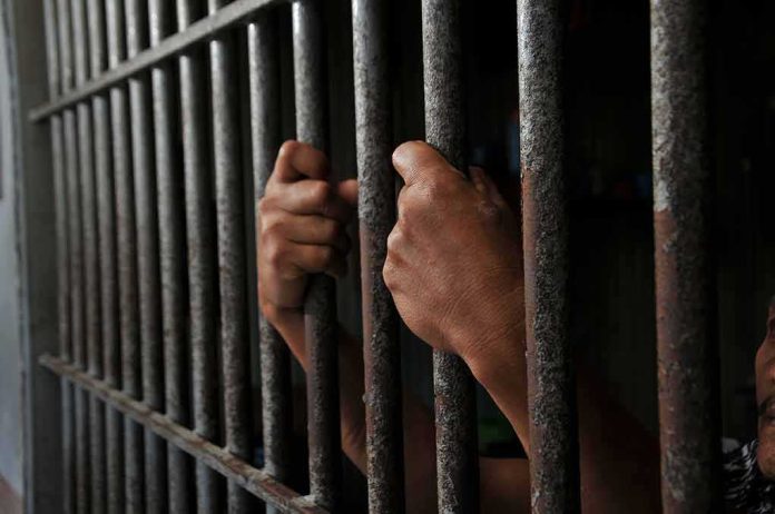 Hands gripping prison cell bars tightly
