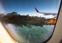 Airplane wing with engine on fire mid flight