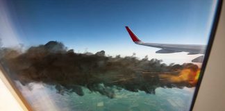 Airplane wing with engine on fire mid flight