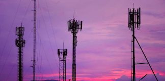 Cell towers against a purple sunset sky