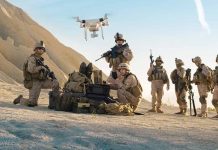 Soldiers operating a drone in a desert environment