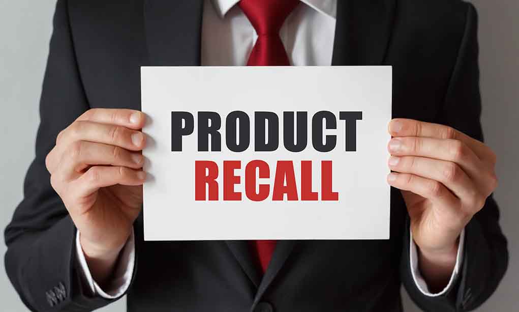 Product Recall sign held by person in suit