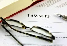 Lawsuit paperwork with glasses pen and an open book