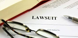 Lawsuit paperwork with glasses pen and an open book