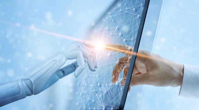 1169699968 Robotic and human hands touching through a screen
