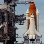 Space shuttle on launch pad with support structure