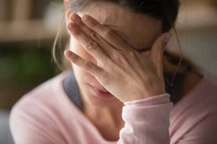 Woman covering face with hand looking stressed