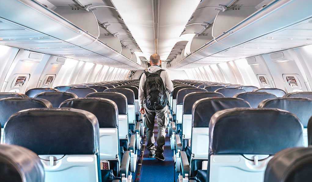 1664709973 Person walking down empty airplane aisle