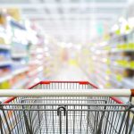 Shopping cart in aisle of grocery store