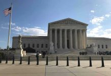 Supreme Court building with flag and people outside