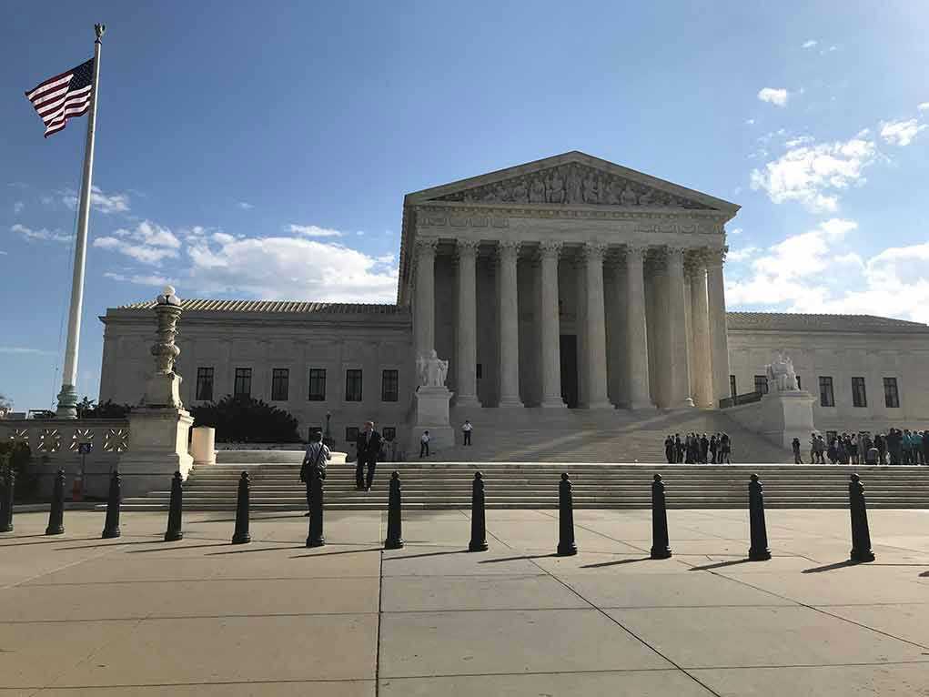 2453289175 Supreme Court building with flag and people outside