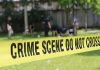 Yellow crime scene tape blocking grassy area