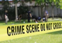 Yellow crime scene tape blocking grassy area