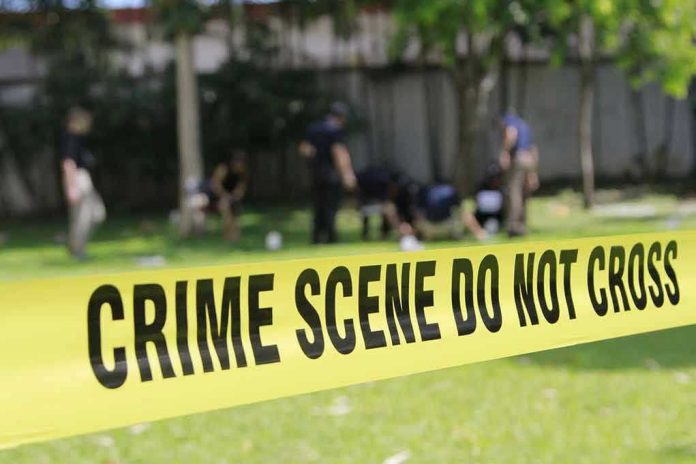 308657879 Yellow crime scene tape blocking grassy area
