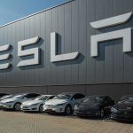 Tesla facility with parked cars in front