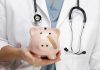 A doctor in a white coat holding a piggy bank with a bandage on it