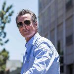 Man in sunglasses wearing a blue button up shirt