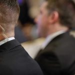 Security personnel with earpiece in a suit.