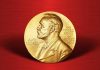Gold Nobel Prize medal on red background