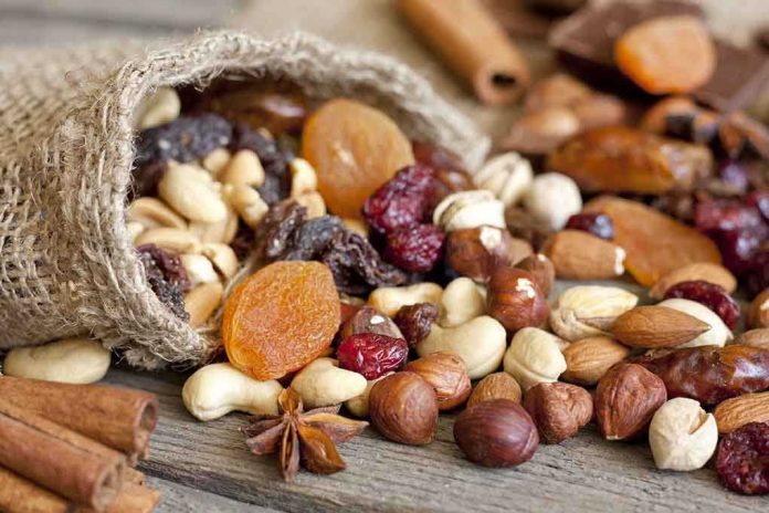 shutterstock_116210527.jpg A burlap sack spilling a variety of nuts and dried fruits on a wooden table