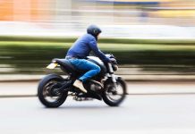 A person riding a motorcycle swiftly through an urban area