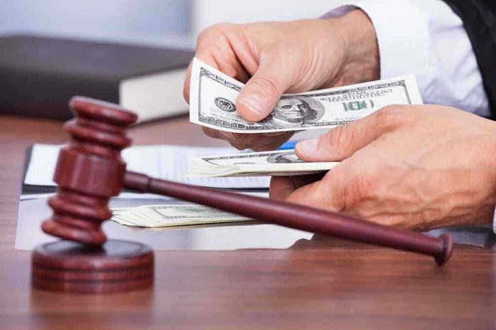 shutterstock_172062569.jpg A person counting cash in a courtroom setting with a gavel in the foreground
