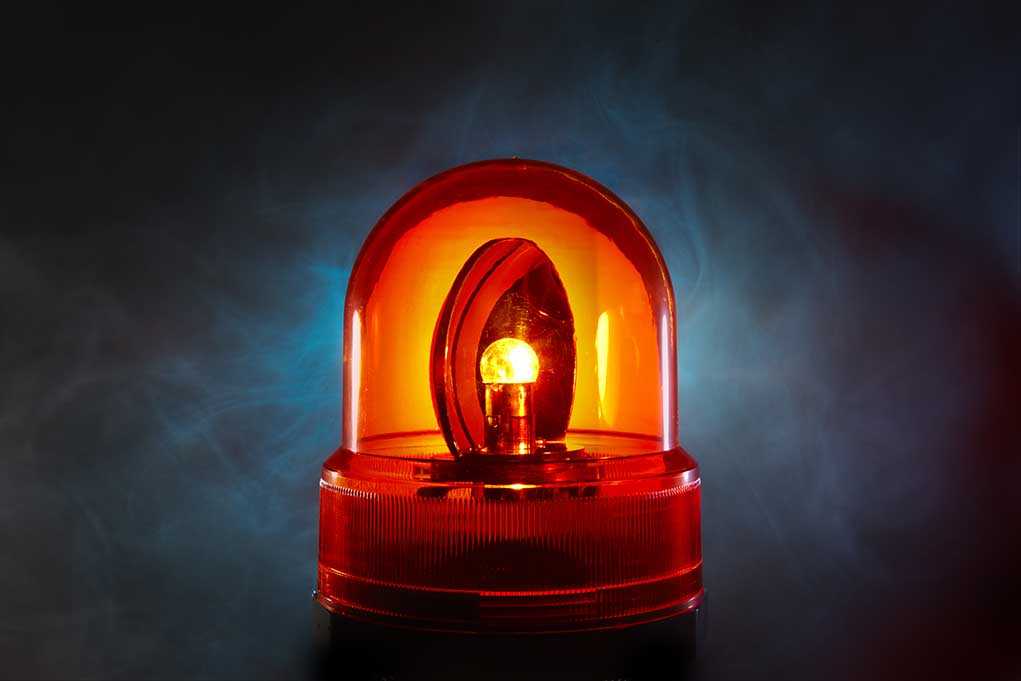 An illuminated orange emergency light on a dark background