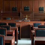 Empty courtroom with wooden furnishings and judges bench.