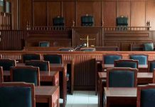 Empty courtroom with wooden furnishings and judges bench.