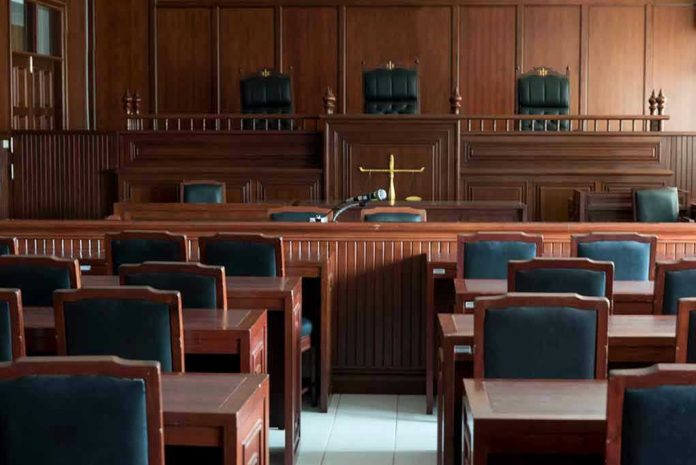 Empty courtroom with wooden furnishings and judges bench.