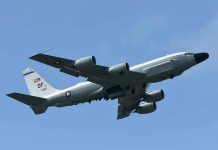 Military aircraft flying in clear blue sky.