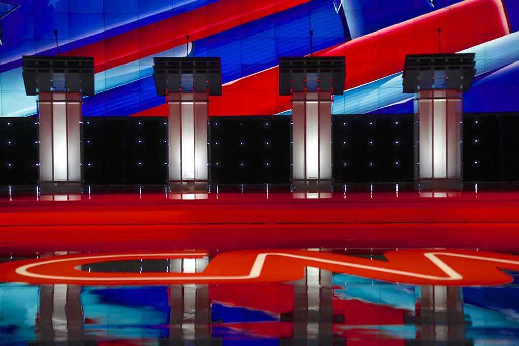 Four debate podiums on a CNN stage background.
