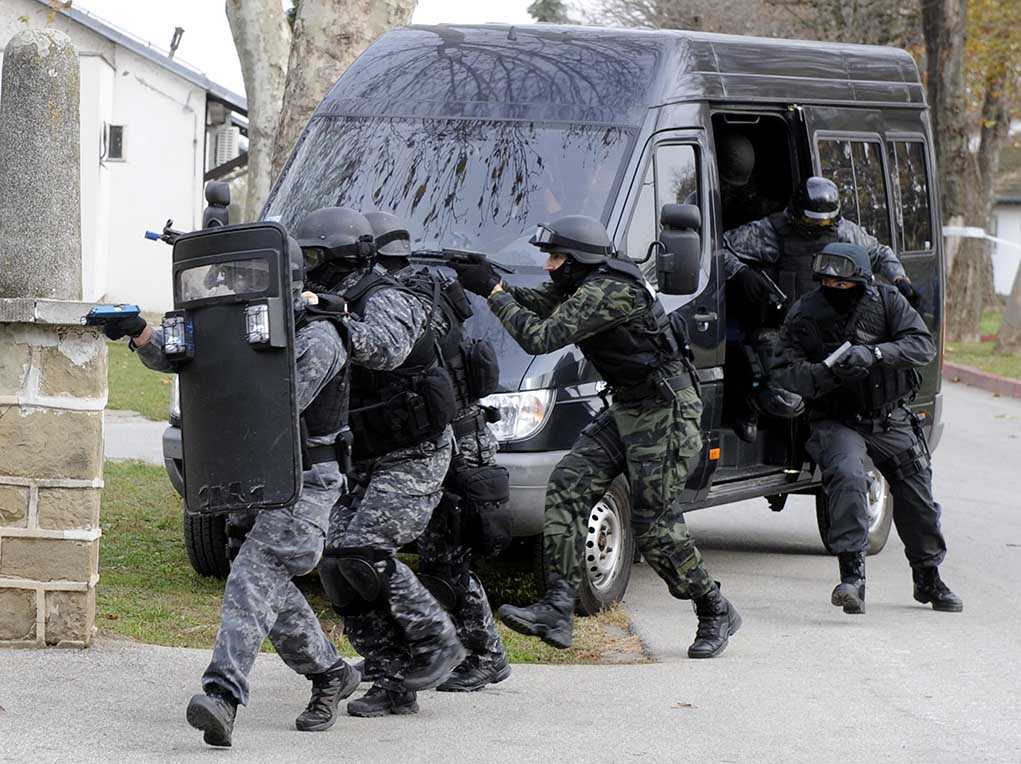 shutterstock_232817302.jpg SWAT team members in tactical gear responding to a situation
