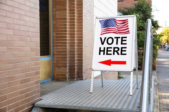 1239383353 Vote Here sign with arrow and American flag.