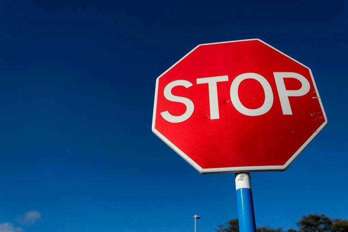 1816713740 Red stop sign against a clear blue sky.