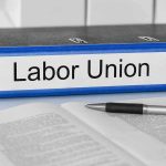 Union Revolt IGNITES: Democrat Mayor, Governor Left Powerless Blue binder labeled Labor Union beside papers and pen.