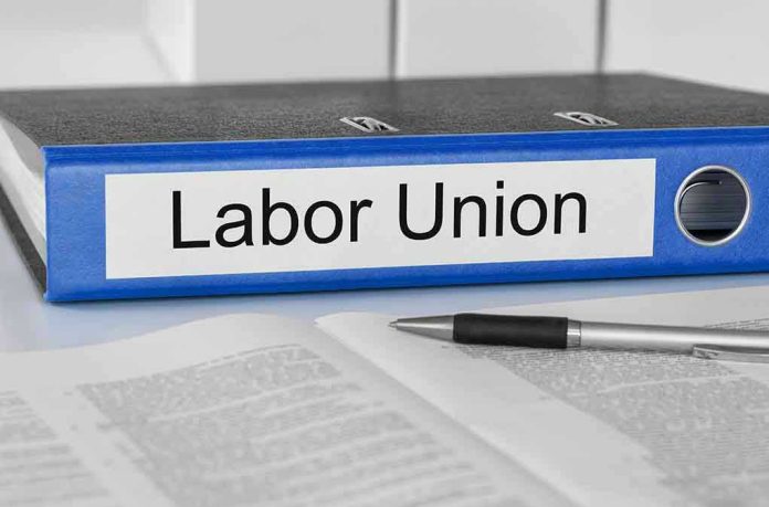 Blue binder labeled Labor Union beside papers and pen.