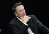 Wikipedia’s Leftist Conspiracy EXPOSED — Musk Responds Man in suit smiling, resting chin on hand.