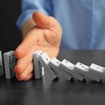 Twelve States DEFY Congress With Bold Power Hand stopping falling row of dominoes.