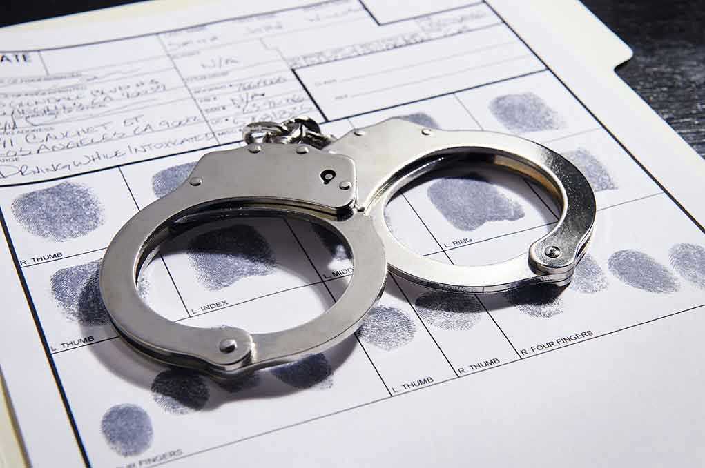 Handcuffs on fingerprint form with fingerprints visible.