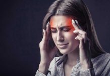 Woman holding head, experiencing intense headache or migraine.