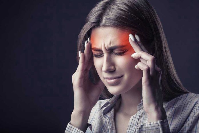 Woman holding head, experiencing intense headache or migraine.