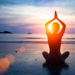 Meditation’s Shocking Gut-Brain Connection Person meditating on the beach during sunset
