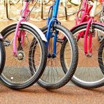 Near-Naked Hiker Stuns Bikers A row of colorful bicycles parked, showcasing their wheels and frames