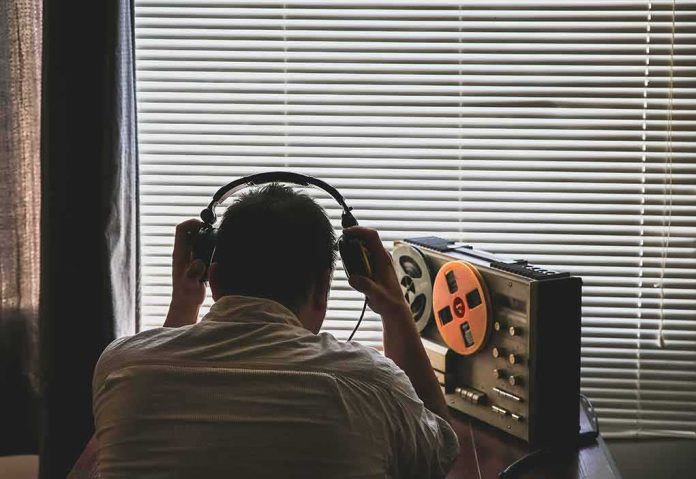 shutterstock_1478666012 (2).jpg Person listening to a vintage tape recorder with headphones