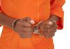 Prison Horror — Diddy in Knife Attack Hands of a person in handcuffs wearing an orange jumpsuit