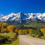 300-Foot Plunge—He Survived The Impossible Scenic view of snow-capped mountains with autumn trees and a winding road